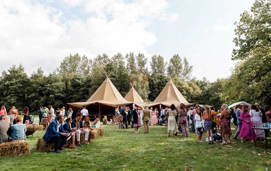 Wedding guests with large tipi behind